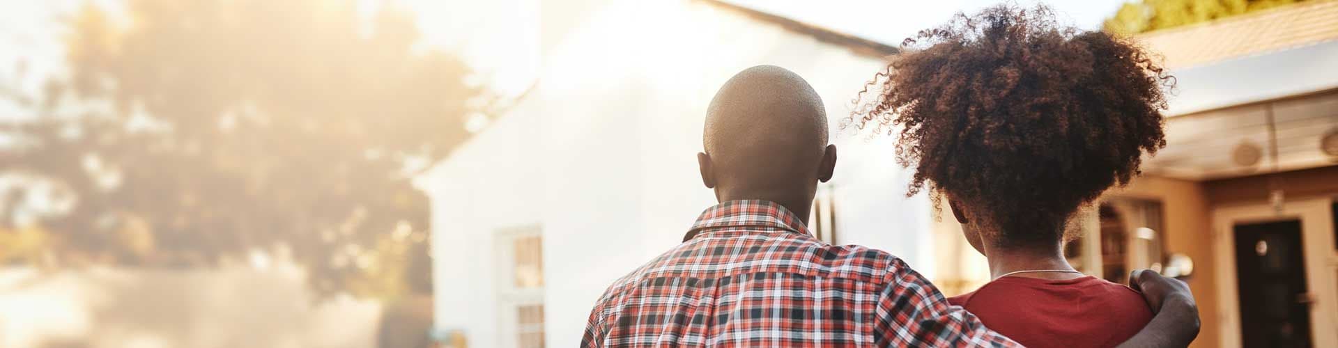 Two people standing in front of home